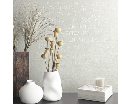 Decoratief interieur met vazen, droogbloemen, boek en kaars voor een muur met een letterpatroon