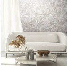Woonkamer met witte bank, salontafel en behang met motief