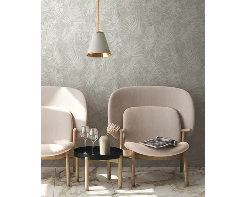 Woonkamer met behang met bladmotief, twee fauteuils, bijzettafel en hanglamp