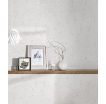 Lichte kamer met witte structuurbehang, versierd met planken, foto''s en een lamp.
