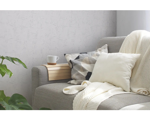 Grijze bank met kussens, deken en bijzettafel in de woonkamer