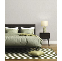 Slaapkamer met bed, nachtkastlamp en behang met patroon