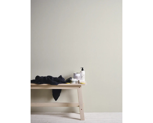 Lichte interieurscène met houten bank, handdoek en diverse badkamerartikelen.