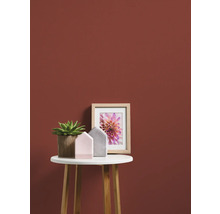 Decoratieve kamerinrichting met plant, fotolijst en decoratieve huisjes op een bijzettafel