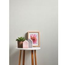 Decoratieve opstelling met potplant, huisfiguren en ingelijste afbeelding op een bijzettafel