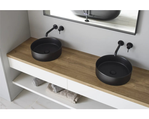 Badkamer met twee ronde opzetwastafels, kranen en wastafelonderkast