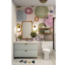 Lichte badkamer met wastafelonderkast, spiegel en toilet tegen een muur met een cirkelpatroon