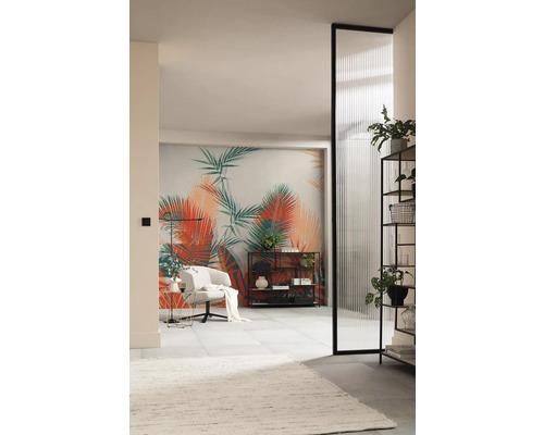 Woonkamer met tropisch fotobehang, fauteuil, rekken en gegroefde glazen deur