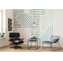 Woonkamer met grafisch behang, fauteuil en bijzettafels