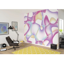 Woonkamer met kleurrijk vliesbehang met abstract patroon, fauteuil, staande lamp en geel tapijt