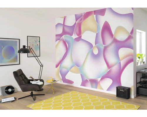 Woonkamer met kleurrijk vliesbehang met abstract patroon, fauteuil, staande lamp en geel tapijt