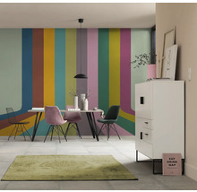 Eetkamer met eettafel, stoelen, dressoir en vloerkleed voor een muur met streepjespatroon