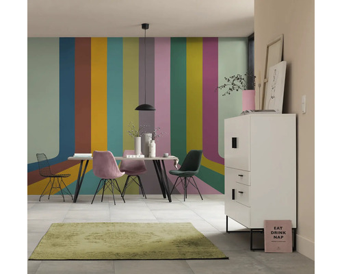 Eetkamer met eettafel, stoelen, dressoir en vloerkleed voor een muur met streepjespatroon