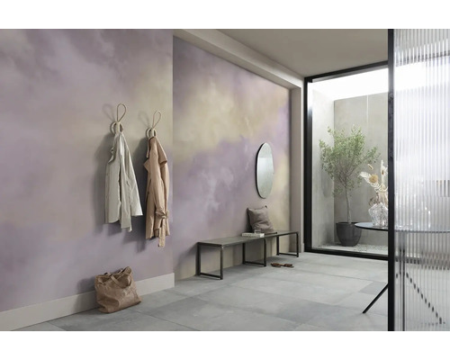 Entree met wanddecoratie in wolkenpatroon, kapstokhaken met jassen, bank en spiegel.