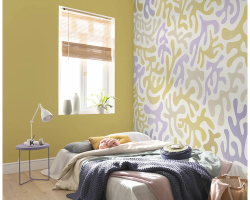 Slaapkamer met bed, nachtkastje en behang met patroon