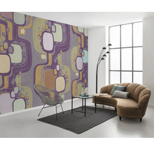 Woonkamer met patroonbehang, bank, fauteuil en vloerkleed