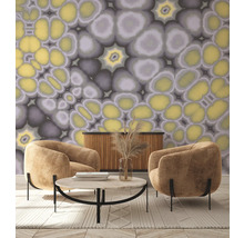 Woonkamer met twee fauteuils, salontafel, dressoir en behang met abstract patroon