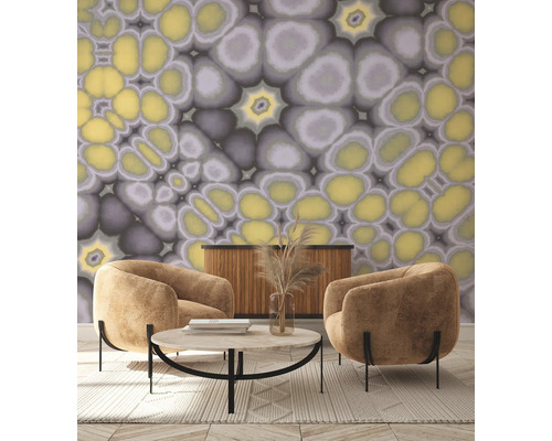 Woonkamer met twee fauteuils, salontafel, dressoir en behang met abstract patroon