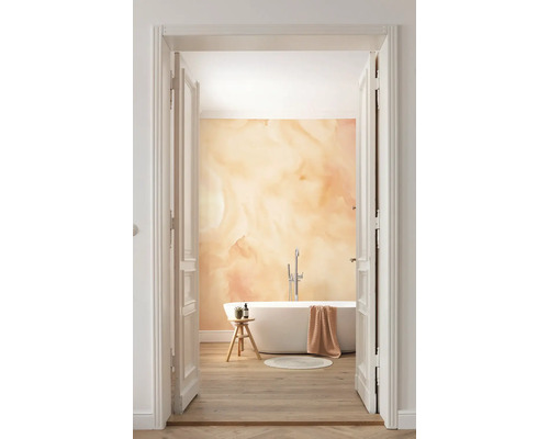 Badkamer met ligbad en abstracte wanddecoratie door een openstaande deur