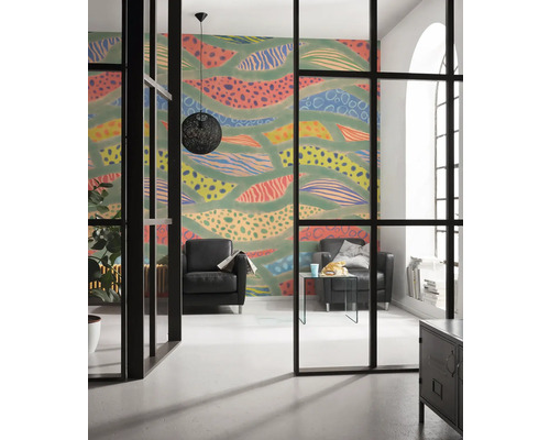 Woonkamer met patroonbehang, zwarte fauteuils en een zwarte hanglamp