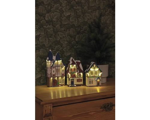 Drie verlichte kersthuisjes in vakwerkstijl op een tafel
