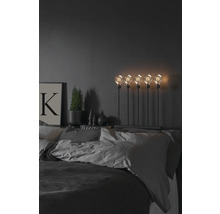 Decoratieve slaapkamer met bed, nachtlamp met vijf gloeilampen, potplant en foto