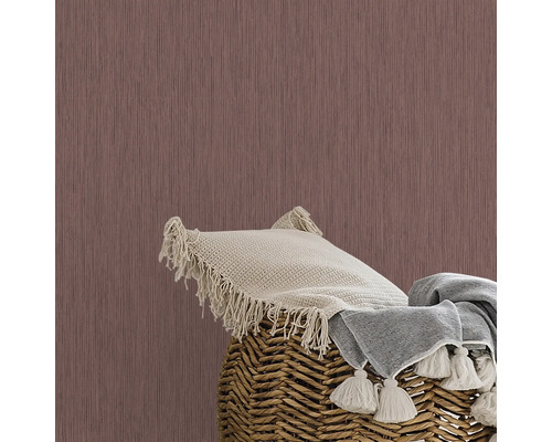 Close-up van een muur met behang, een kussen en een deken in een mand