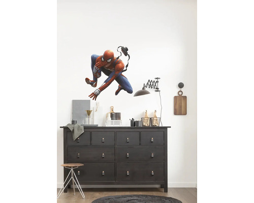 Woonkamer met donkere commode en muursticker van Spiderman.