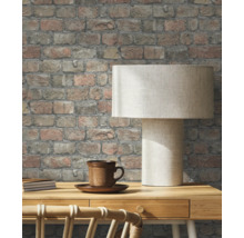 Decoratief bakstenen behang in de woonkamer met tafellamp en kopje.