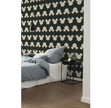 Slaapkamer met bed, nachtkastje en behang met Mickey Mouse motief