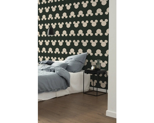 Slaapkamer met bed, nachtkastje en behang met Mickey Mouse motief
