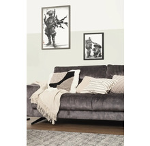 Decoratieve woonkamer met bank, kussens en ingelijste illustraties aan de muur