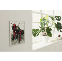 Woonkamer met een ingelijste afbeelding van het stripfiguur Deadpool en een kamerplant in een witte pot op een vensterbank.