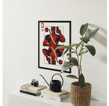 Ingelijste Deadpool poster boven een plank met boeken, een camera, een gieter en een plant.