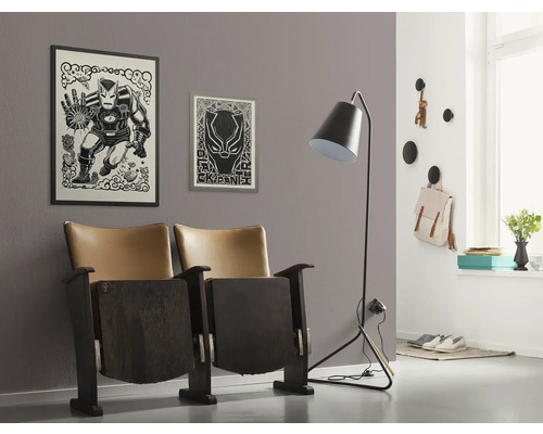 Woonkamer met twee bioscoopstoelen, een vloerlamp en wanddecoratie