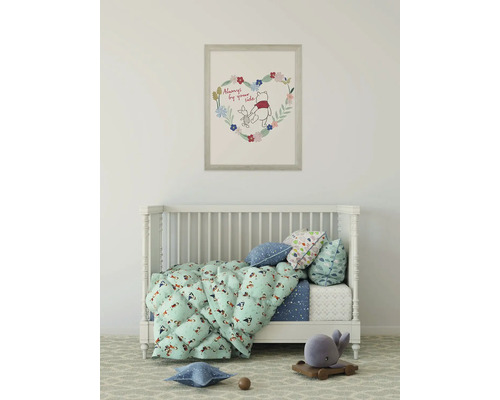 Kinderkamer met ledikant, beddengoed en een ingelijste Winnie de Poeh afbeelding aan de muur