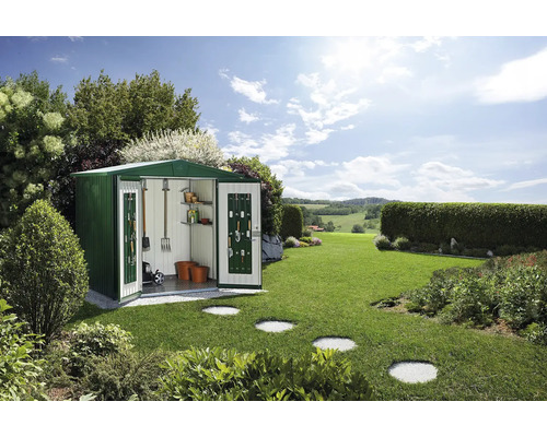 Metalen tuinhuis met open deuren en tuingereedschap in een groene buitenruimte