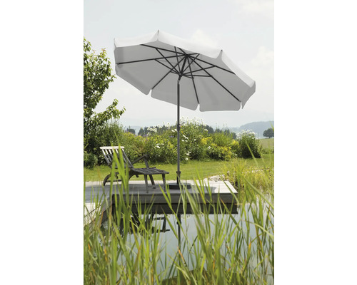 Tuinscene met parasol, ligstoel en vijver op een houten terras