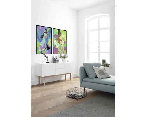 Lichte ruimte met twee ingelijste muurschilderingen, een dressoir, een lamp, een bank, een mand en een vloerkleed.