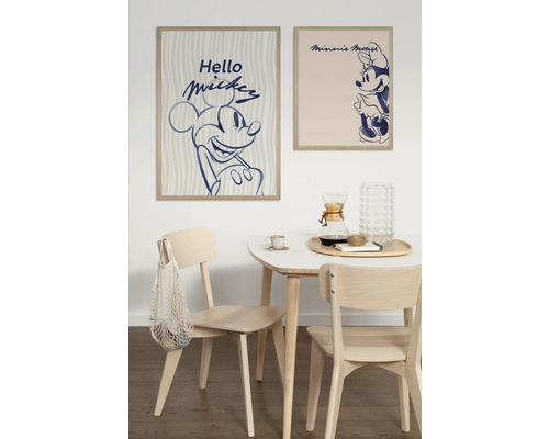 Eetkamer met houten tafel en stoelen onder ingelijste Mickey Mouse en Minnie Mouse posters