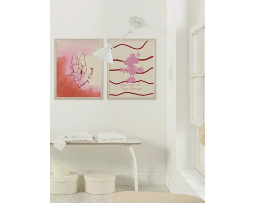 Wanddecoratie met twee ingelijste Disney-motieven, tafel en lamp in een heldere ruimte