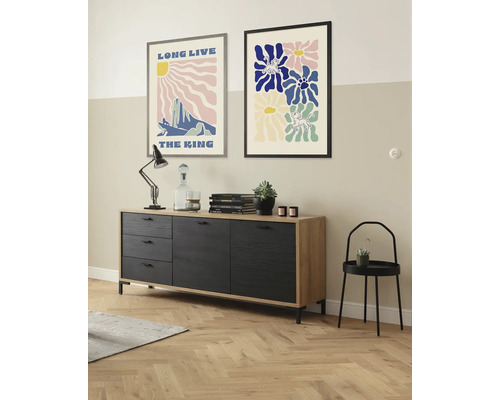 Inrichtingsvoorbeeld met dressoir, afbeeldingen en decoratie in een woonkamer.