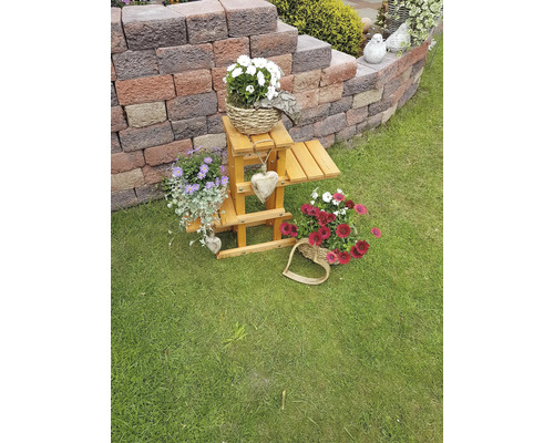 Decoratieve houten ladder met bloemstukken in de tuin