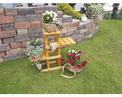 Decoratieve tuinscène met bloemen, bloemenstandaard en stenen muur