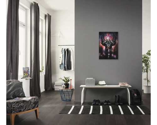 Woonkamer met fauteuil, kledingrek, bank en muurschildering