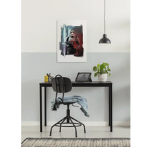 Schilderij van een soldaat aan een muur boven een bureau