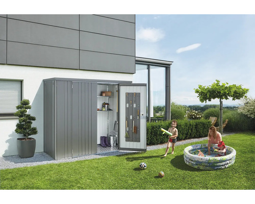 Tuinscène met een metalen gereedschapskast tegen een gebouw waarin gereedschap is opgeslagen. Kinderen spelen in een opblaasbaar zwembad.