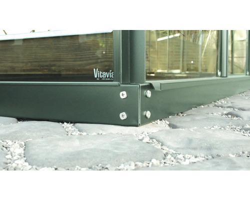 Detailopname van een tuinkasfundament met schroeven en Vitavia logo