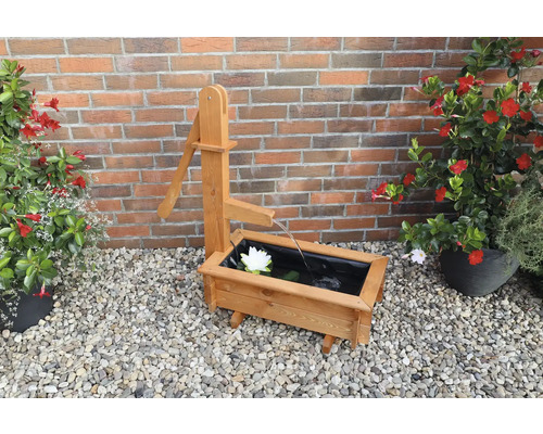 Decoratieve houten fontein met waterpomp en waterlelie in de tuin