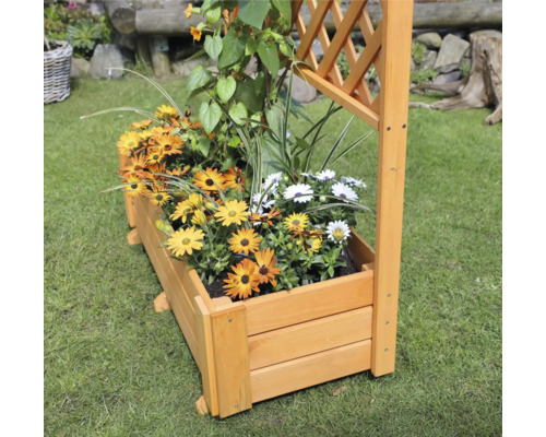 Houten plantenbak met klimrek en kleurrijke bloemen op een gazon